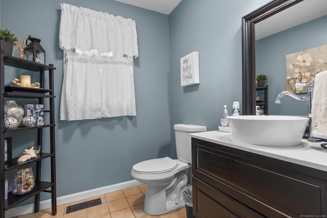 half bathroom with toilet, vanity, baseboards, visible vents, and tile patterned floors