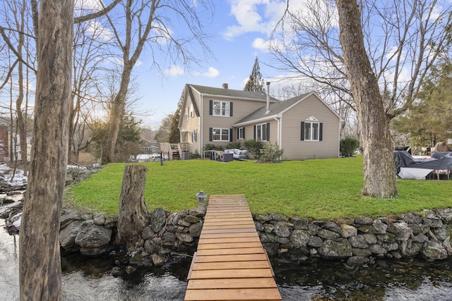 rear view of house with outdoor lounge area, a yard, and a chimney