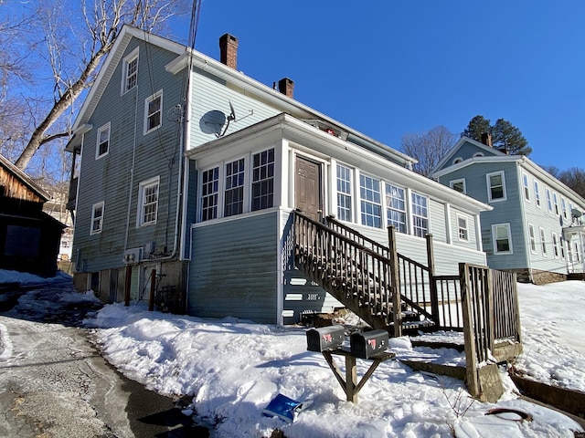 view of front of house featuring stairs and a chimney