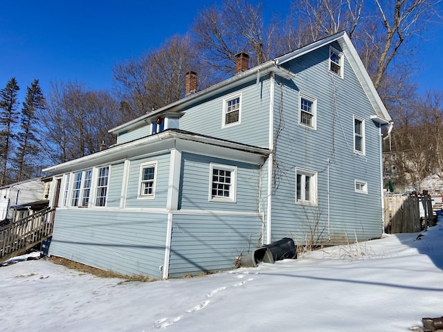 view of snowy exterior with a chimney