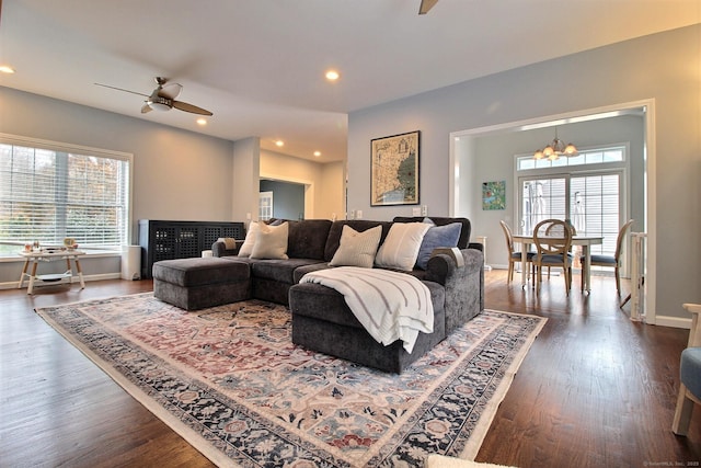 living room featuring recessed lighting, a healthy amount of sunlight, dark wood finished floors, and ceiling fan with notable chandelier