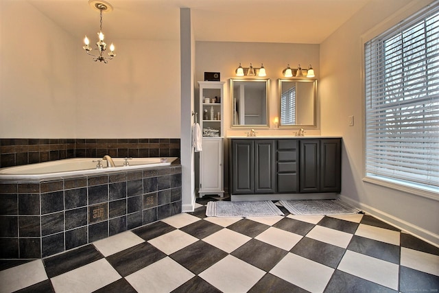 full bath featuring double vanity, baseboards, a bath, an inviting chandelier, and a sink