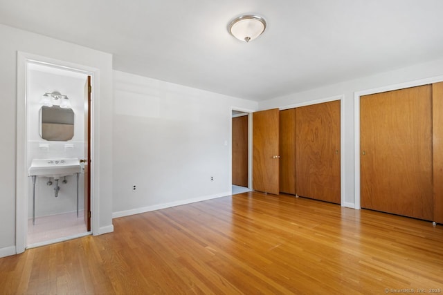 29 Maplewood Dr, Greenwich, CT 06807 - unfurnished bedroom with multiple closets, wood finished floors, ensuite bathroom, and a sink