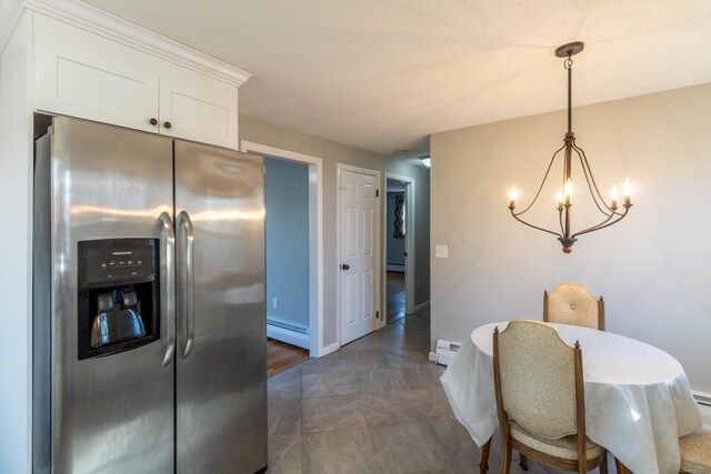 dining area featuring an inviting chandelier, a baseboard radiator, and baseboards