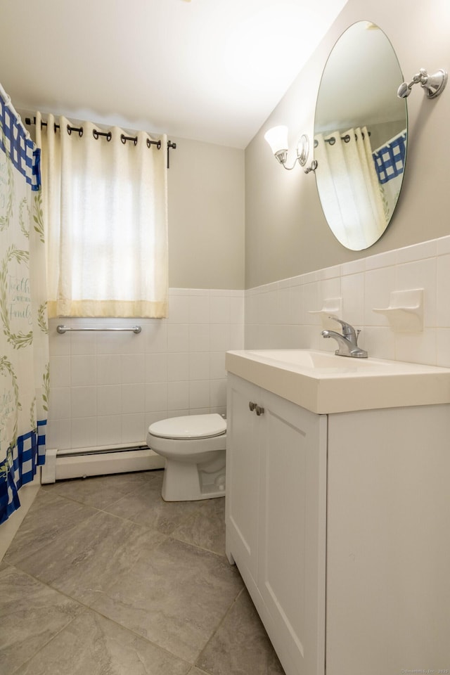 full bath featuring wainscoting, toilet, a baseboard radiator, vanity, and tile walls