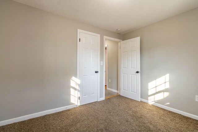 unfurnished bedroom featuring carpet and baseboards