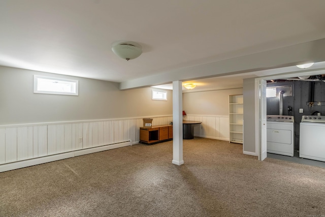 below grade area with a wainscoted wall, carpet, a baseboard heating unit, and washing machine and clothes dryer