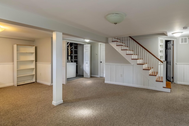 finished below grade area featuring carpet floors, stairway, and visible vents