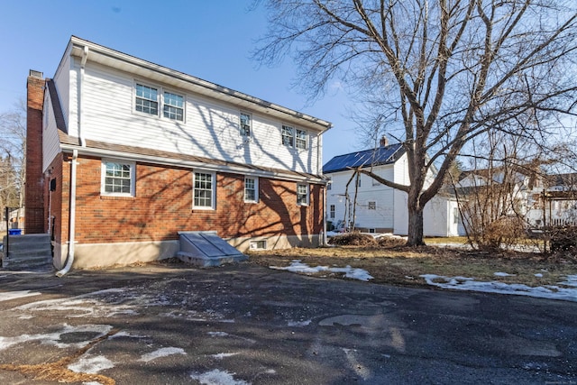 exterior space with brick siding and a chimney