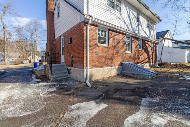 view of side of property featuring brick siding and a chimney