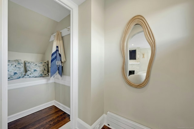 interior space featuring baseboards, lofted ceiling, and dark wood-style floors