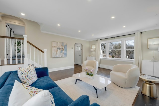 living area featuring baseboards, stairway, radiator heating unit, wood finished floors, and arched walkways