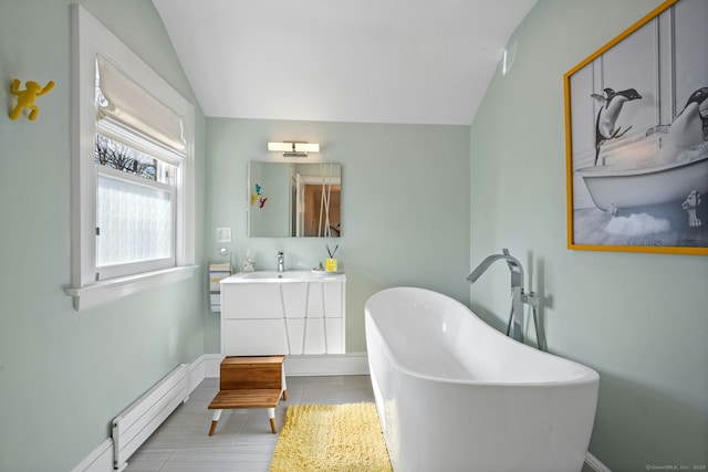 full bathroom featuring vanity, baseboards, a soaking tub, vaulted ceiling, and baseboard heating