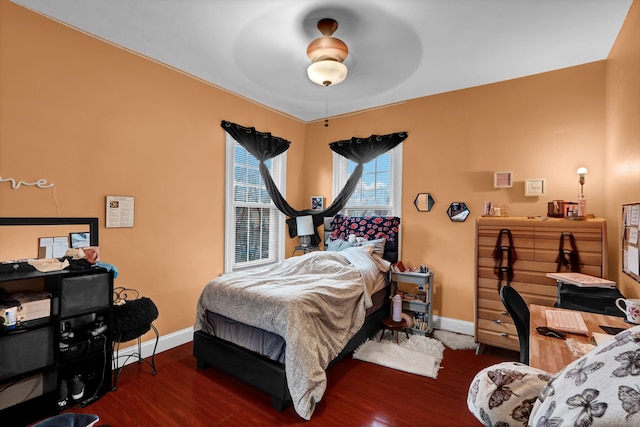 bedroom with wood finished floors, a ceiling fan, and baseboards