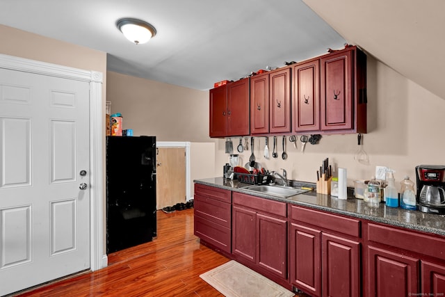 kitchen featuring dark brown cabinets, dark countertops, and a sink