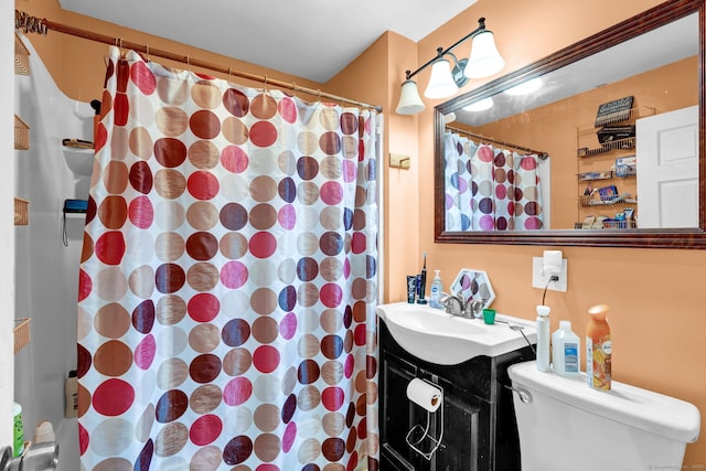 bathroom featuring curtained shower, vanity, and toilet