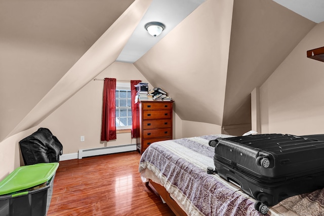 bedroom with lofted ceiling, baseboard heating, wood finished floors, and baseboards