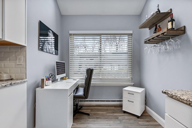 office area featuring baseboards, plenty of natural light, a baseboard heating unit, and wood finished floors