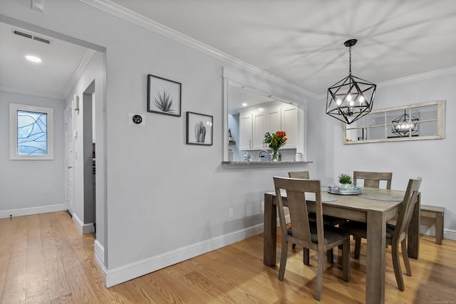 dining area with light wood finished floors, baseboards, and visible vents