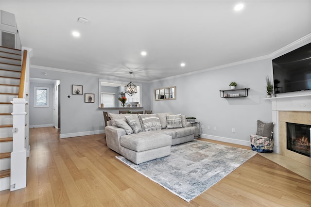 living room with light wood finished floors, stairway, and ornamental molding