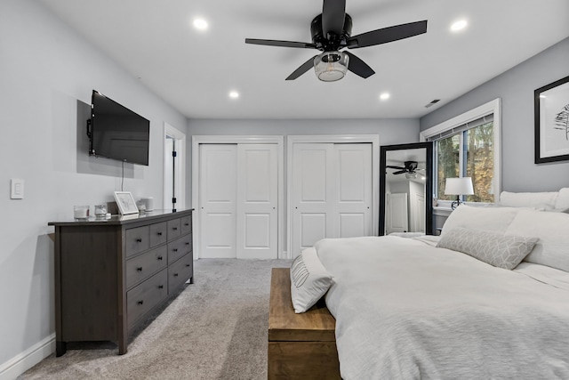 carpeted bedroom featuring baseboards, visible vents, a ceiling fan, two closets, and recessed lighting