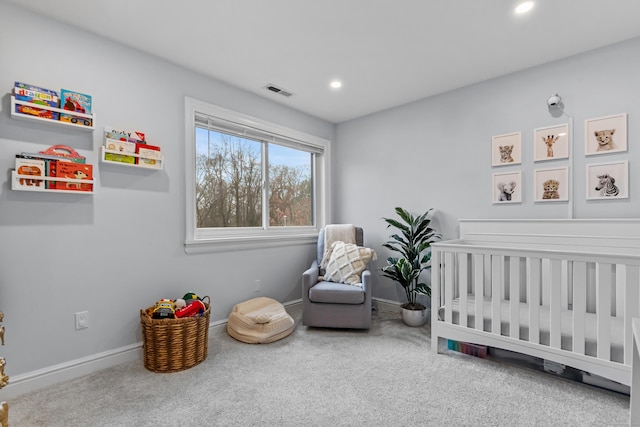 bedroom featuring carpet floors, a crib, visible vents, and baseboards