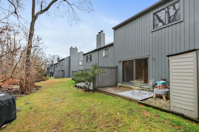 exterior space featuring a patio, a lawn, and a chimney