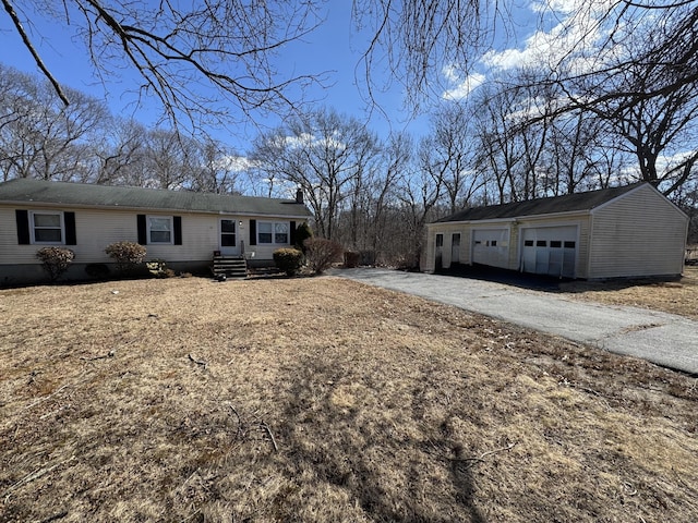 ranch-style home with a detached garage and an outbuilding