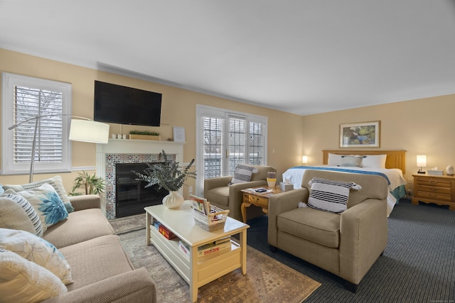 carpeted bedroom featuring multiple windows and a glass covered fireplace