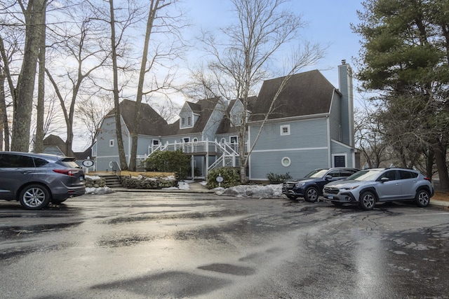 view of front of property with uncovered parking and a chimney