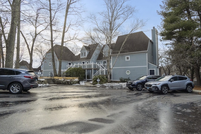 313 Old Pond Ln Unit 313, Norwich, CT 06360 - view of front facade featuring a chimney, stairs, and uncovered parking