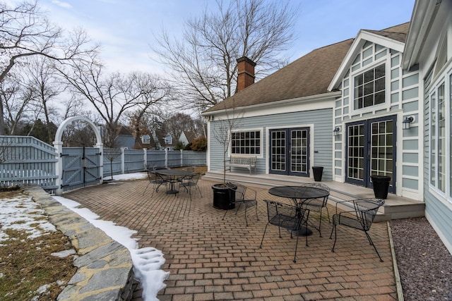 view of patio / terrace featuring french doors, outdoor dining area, fence, and a gate