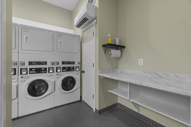 community laundry room featuring stacked washer and dryer, an AC wall unit, and dark tile patterned flooring