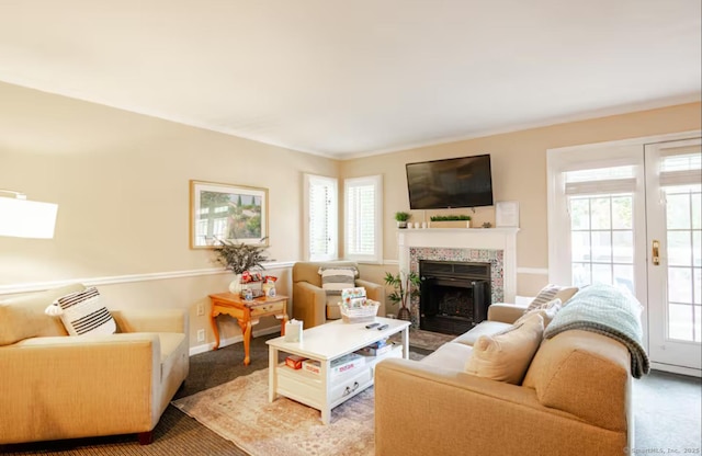 carpeted living room featuring a tile fireplace and baseboards