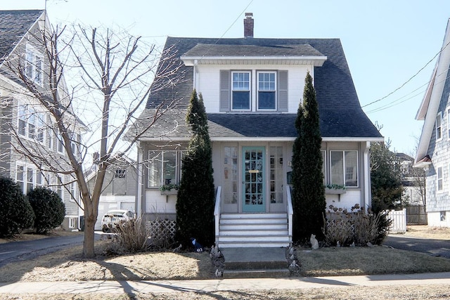 view of front facade featuring roof with shingles, a chimney, fence, and central air condition unit