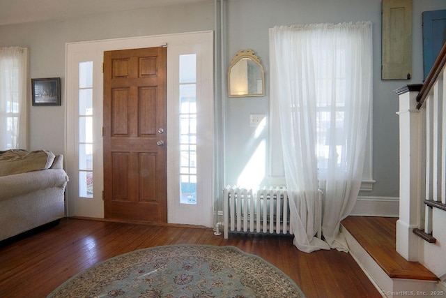 entrance foyer featuring stairs, radiator heating unit, and wood finished floors