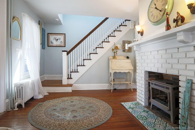 interior space with radiator, a fireplace, baseboards, and wood finished floors