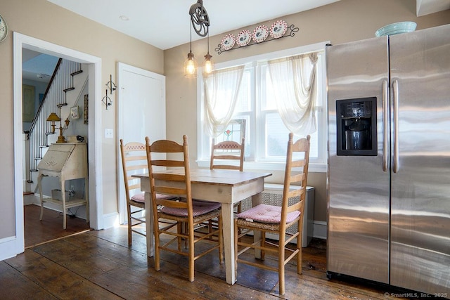 dining space featuring wood-type flooring, stairs, and baseboards