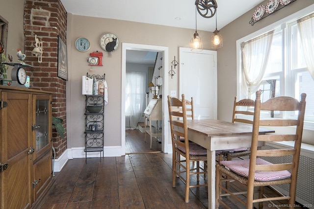 dining space featuring baseboards and dark wood-type flooring