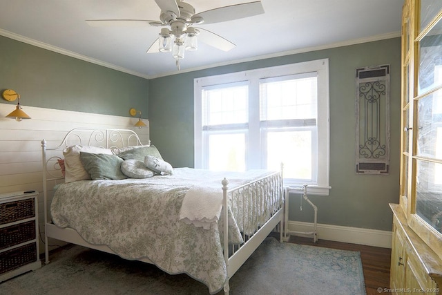 bedroom with baseboards, ceiling fan, wood finished floors, and crown molding