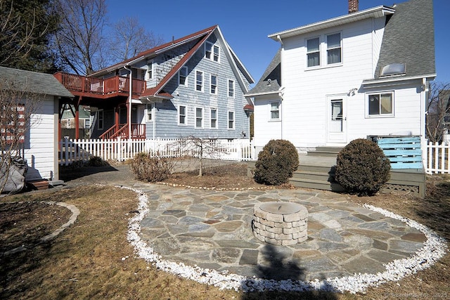 rear view of property with a patio area, a shingled roof, a chimney, and fence