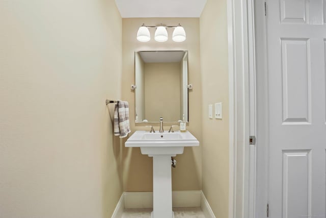 bathroom with a sink and baseboards