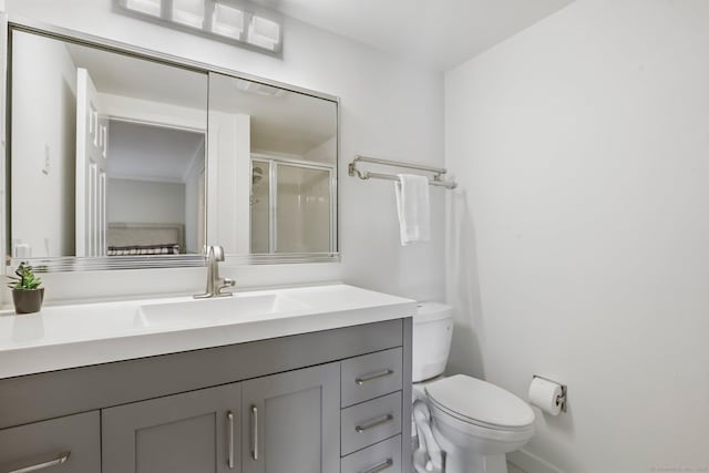 bathroom featuring toilet, a shower stall, and vanity