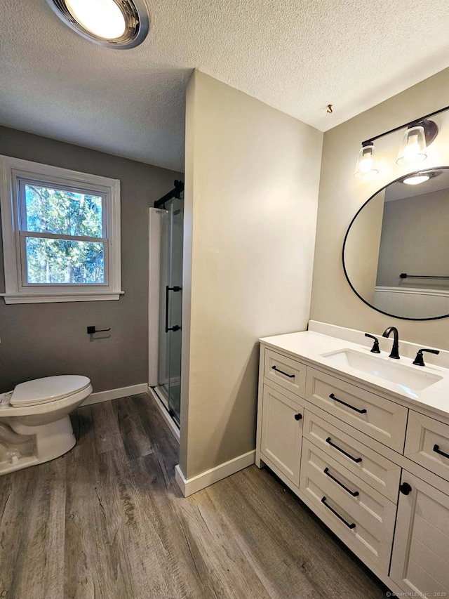 full bath featuring a stall shower, toilet, baseboards, and wood finished floors