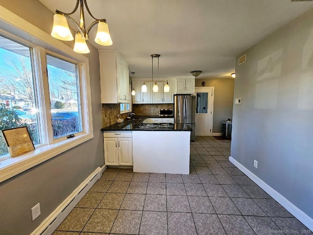 kitchen with a baseboard radiator, dark countertops, appliances with stainless steel finishes, white cabinetry, and a sink