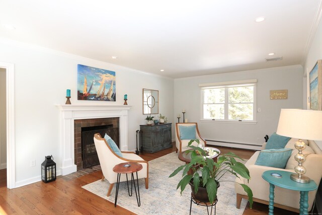 living area with visible vents, crown molding, baseboard heating, and wood finished floors