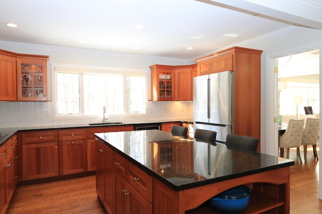 kitchen with wood finished floors, open shelves, freestanding refrigerator, a sink, and crown molding