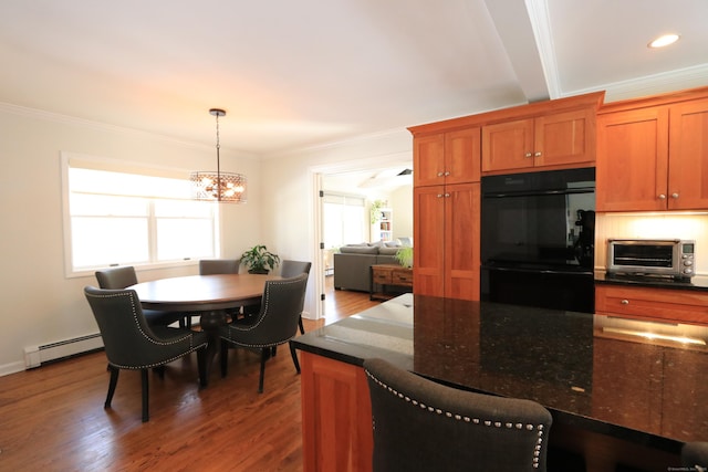 kitchen with a toaster, ornamental molding, baseboard heating, wood finished floors, and dobule oven black