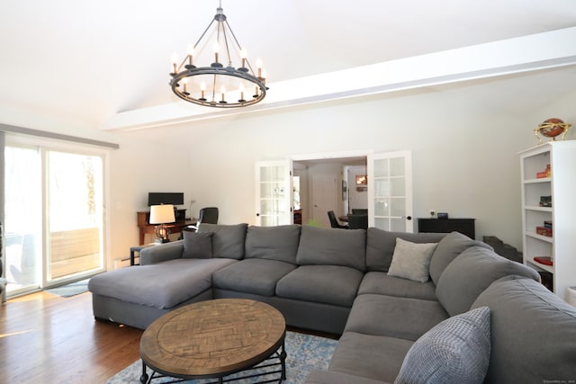 living room featuring lofted ceiling, an inviting chandelier, wood finished floors, and french doors