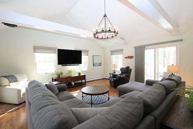 living area with lofted ceiling, wood finished floors, a chandelier, and a healthy amount of sunlight